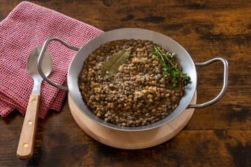 lentils cooked in a dish with bay leaf on a table