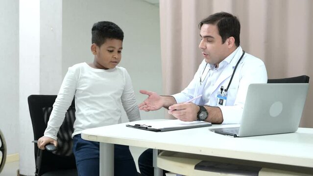 A doctor at an international hospital Trying to check up of a mischievous child in the hospital's OPD examination room.