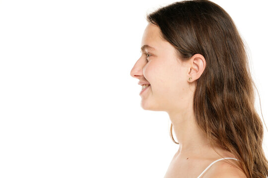 Profile of a young smiling woman without makeup on a white background