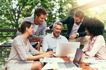 They meet, plan and make it happen. Shot of a team of colleagues using a laptop together during a meeting outdoors.