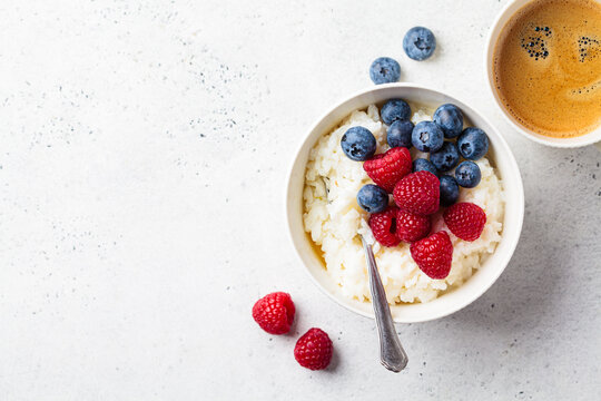 Rice pudding with berries and butter. Porridge bowl with raspberries and blueberries.