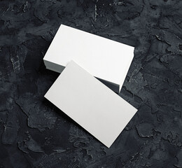 Blank white business cards on black plaster background. Mockup for branding identity. Blank...