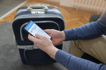 Man holding smart phone with flight cancelled on screen.
Flight Delayed notificationon Smartphone...