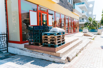 Empty pallets outside the store. Wooden pallets on a hydraulic trolley. Warehousing equipment. Sold out commodities during panic buy. Goods deficit and shortage due to economic crisis.