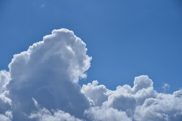 Białe spiętrzone chmury na błękitnym niebie