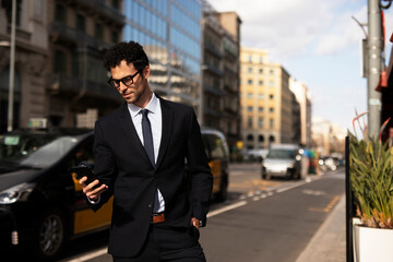 Fototapeta na wymiar Handsome businessman using the phone. Young elegance man outdoors..