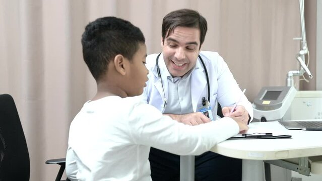 A doctor at an international hospital Trying to check up of a mischievous child in the hospital's OPD examination room.