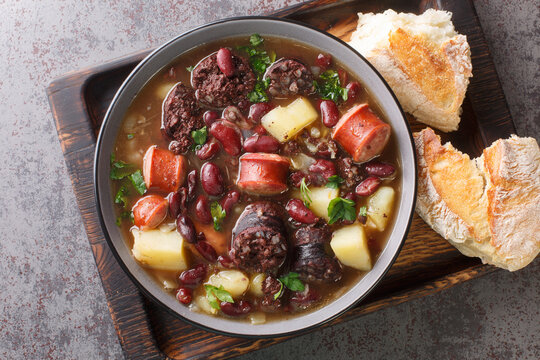 Slow Cooked Portuguese Stone Soup or Sopa da Pedra closeup in the plate on the table. Horizontal top view from above