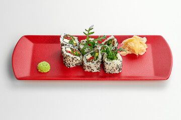 Vegetable, vegetarian sesame sushi roll in a red plate on a gray background