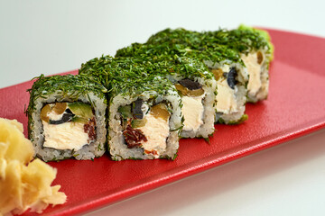 Vegetable, veggie sushi roll in dill in a red plate on a gray background