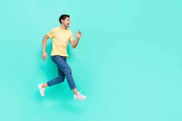 Full length profile photo of satisfied cheerful man run look empty space isolated on turquoise color background