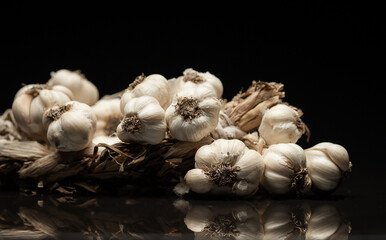 Fragrant Garlic wreath lies on dark background. Agriculture and farming