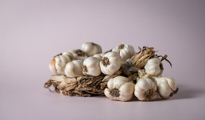 Fragrant Garlic wreath lies on light background. Agriculture and farming