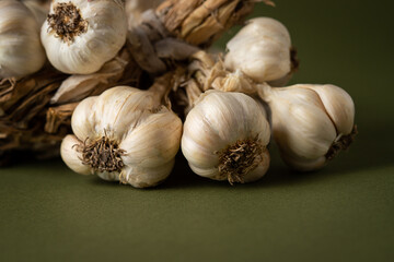 Fragrant Garlic wreath lies on olive background. Agriculture and farming