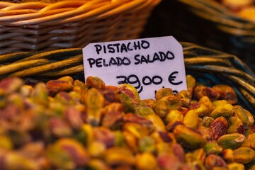 Nut store, bulk pistachio ready for sale, the sign translated into English means salted peeled...