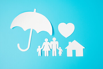 Umbrella cover family, home and heart shape paper on blue background. International day of families, Healthcare, wellness and Insurance concept