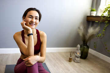 I feel refreshed after training. A portrait of an attractive young woman stretching out on a yoga mat. A middle-aged Asian woman leads a healthy life, training in her home in her modern living room.