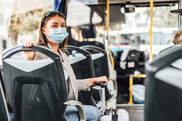 A young woman wearing mask commuting by the public bus