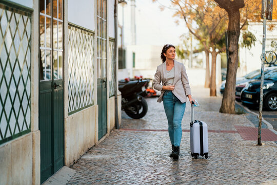Portrait of traveling woman with luggage in the city