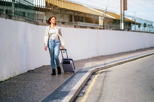 Portrait of traveling woman with luggage in the city