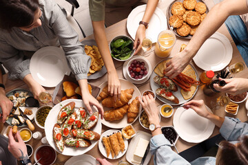 Group of people having brunch together at table, top view - obrazy, fototapety, plakaty