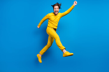 Fototapeta premium Full length body size view of attractive cheerful guy jumping having fun isolated over bright blue color background