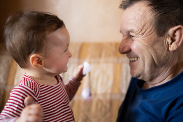 Happy baby and her grandpa smiling to each other