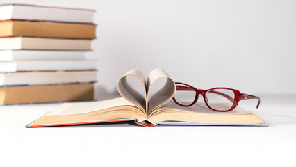 A stack of books on a white background. Glasses on the top book. World book day concept.