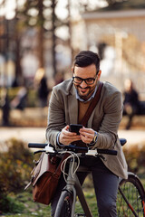 Fototapeta na wymiar Lovely, bearded caucasian man, stopping his bike ride, typing a text.
