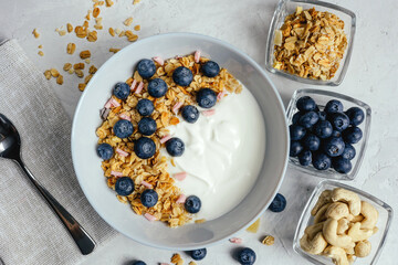 Yogurt with muesli and berries on a gray background.