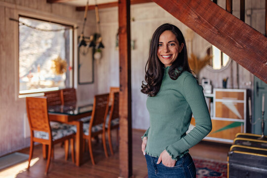 Portrait of a woman, holding hands in pockets, standing and posi
