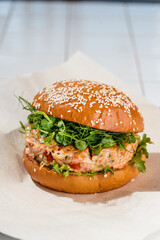 Burger with crab and shrimp patty. spinach, frisee salad, roasted peppers, corn, spicy sauce, white bun, microgreens