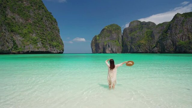 Young woman traveler relaxing and enjoying at beautiful tropical white sand beach at Maya bay in Krabi, Thailand, Summer vacation and Travel concept	