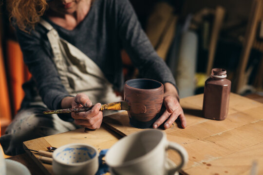 Woman Carving Pottery In Her Workshop