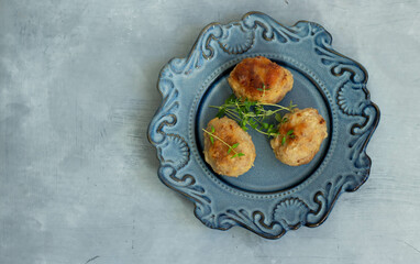 Cutlets with thyme on a blue plate. View from above.