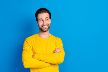 Portrait of attractive cheerful minded brunet guy folded arms deciding copy space isolated over bright blue color background