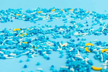 Sugar sprinkles in shape of star moon sticks on light blue background. Spase for text. Easter concept.
