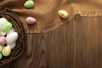 Colored chicken and quail eggs in a nest on a wooden background. Top view. Free space. Easter eggs. High quality photo