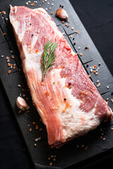 Raw ribs with rosemary on a black board