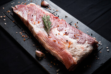 Raw ribs with rosemary on a black board