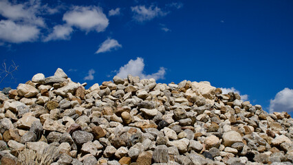 Stones of various structures deposited on the edge of the field. Heap of waste stones.