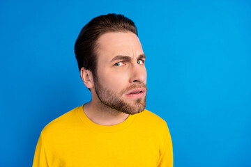 Portrait of attractive funny suspicious doubtful brunet guy looking investigation isolated over bright blue color background