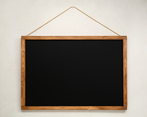 Clean black chalkboard hanging on white wall
