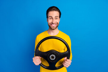Portrait of attractive cheerful brunet guy holding steering wheel road way isolated over bright...