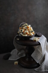 White chocolate candies with nuts, dried fruits and chocolate chip cookies. Homemade fudge in a vintage plate