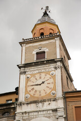Close up of the municipal tower located at Piazza Grande in Modena, Italy. In the center of the tower there is an ancient clock.