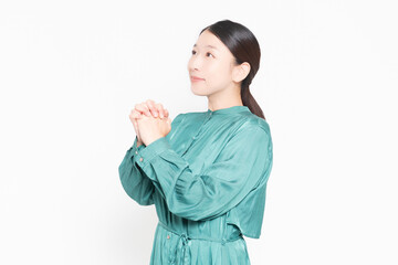 指を組んでお願いのポーズをする主婦