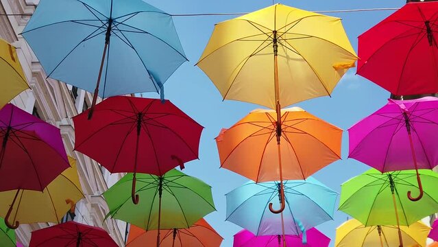 multicolored umbrella hanging on the street on a sunny day