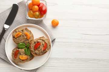 Slices of fresh bread with delicious pate and tomatoes on white wooden table, flat lay. Space for text
