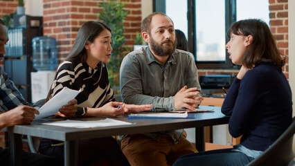 Angry woman being dismissed from human resources job and leaving meeting, breaking papers because...